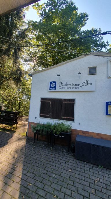 Helles Gebäude mit dem Schriftzug „Pension Point“ und Bäumen im Hintergrund.